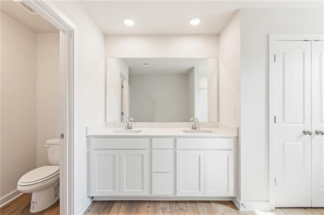 full bath featuring visible vents, double vanity, a sink, and toilet