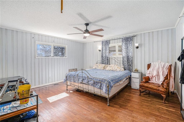 bedroom featuring a textured ceiling, wood finished floors, and a ceiling fan