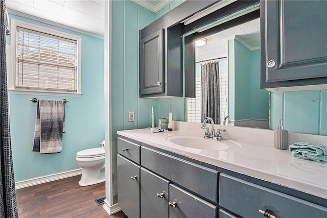 full bath with toilet, ornamental molding, wood finished floors, and vanity