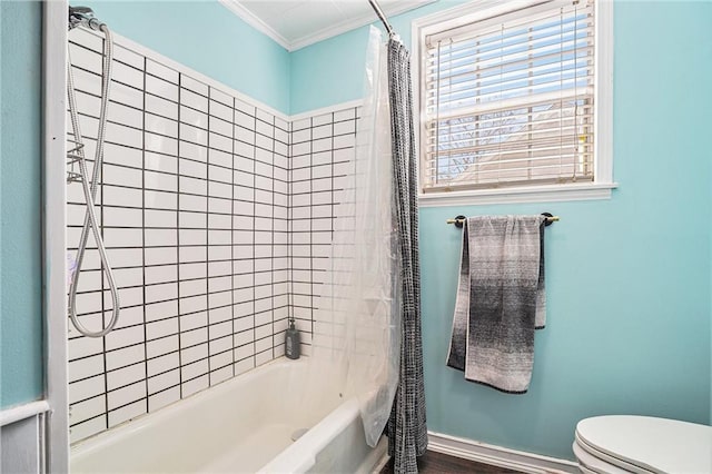 bathroom with ornamental molding, shower / bath combo with shower curtain, toilet, and baseboards