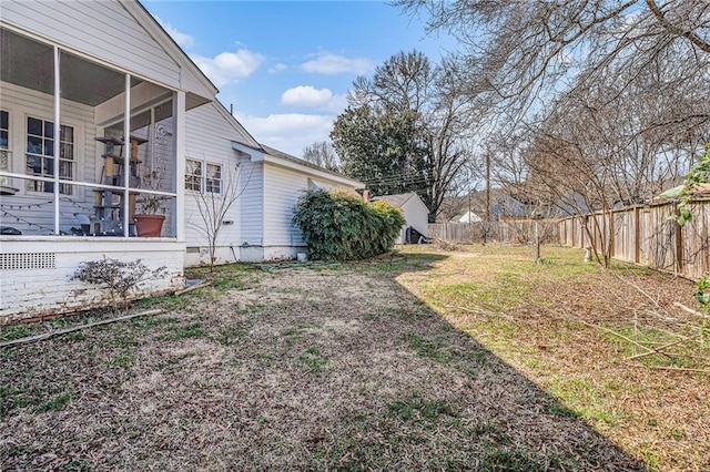 view of yard featuring a sunroom and fence