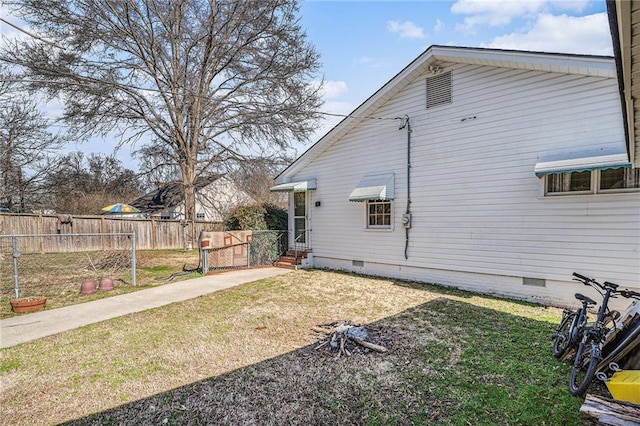 view of home's exterior with crawl space, fence, and a yard