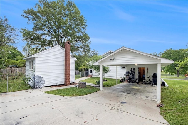 exterior space featuring driveway, a front yard, a carport, and fence
