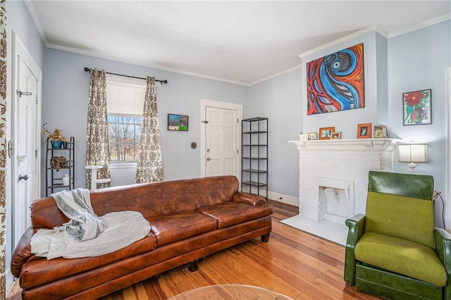 living area featuring baseboards, a fireplace, ornamental molding, and wood finished floors