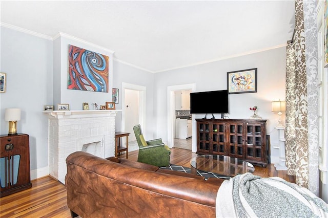 living room with hardwood / wood-style floors, a brick fireplace, a textured ceiling, and crown molding