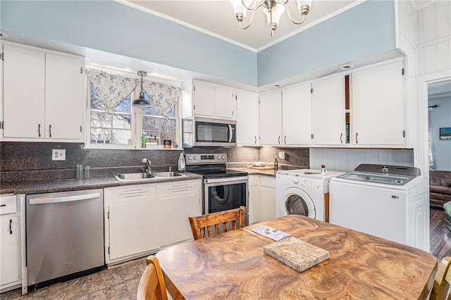 kitchen with ornamental molding, appliances with stainless steel finishes, a sink, and washer / dryer