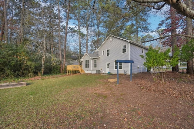 rear view of house with a deck and a yard