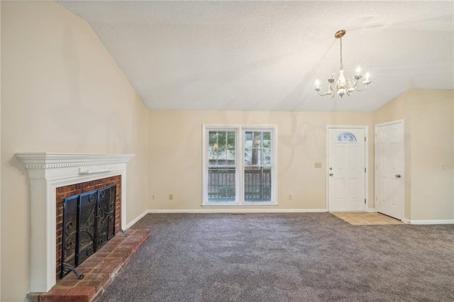 unfurnished living room featuring a fireplace, carpet, lofted ceiling, and an inviting chandelier