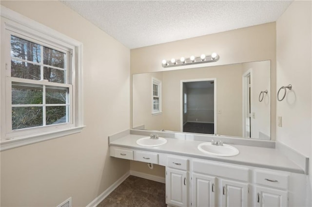 bathroom featuring plenty of natural light, a textured ceiling, and vanity