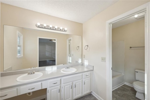 full bathroom with vanity,  shower combination, toilet, and a textured ceiling