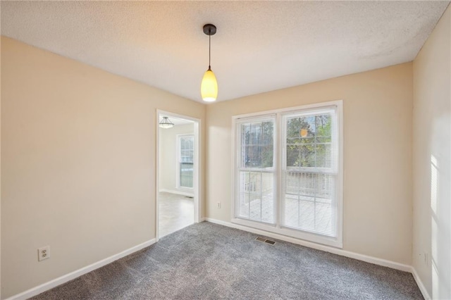 carpeted empty room with a textured ceiling