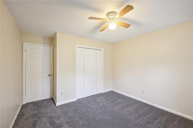 unfurnished bedroom with ceiling fan, a closet, dark carpet, and a textured ceiling