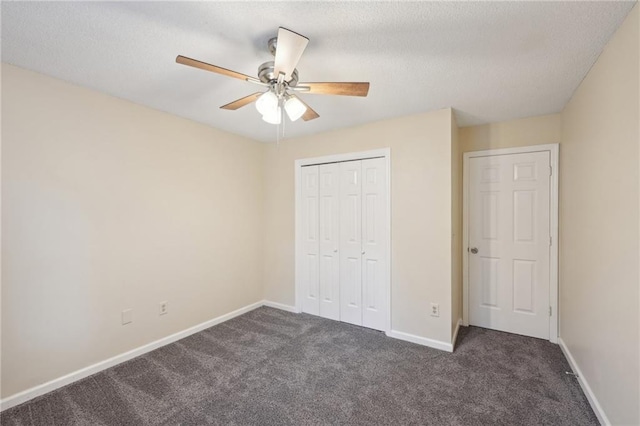 unfurnished bedroom featuring ceiling fan, a closet, a textured ceiling, and dark colored carpet