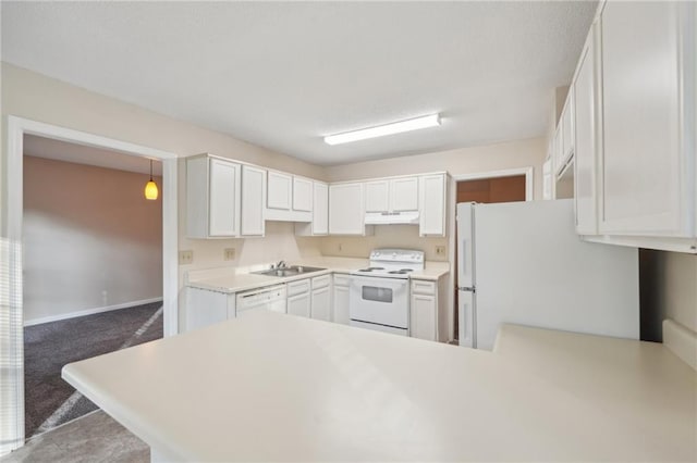 kitchen featuring white appliances, white cabinets, dark colored carpet, decorative light fixtures, and kitchen peninsula