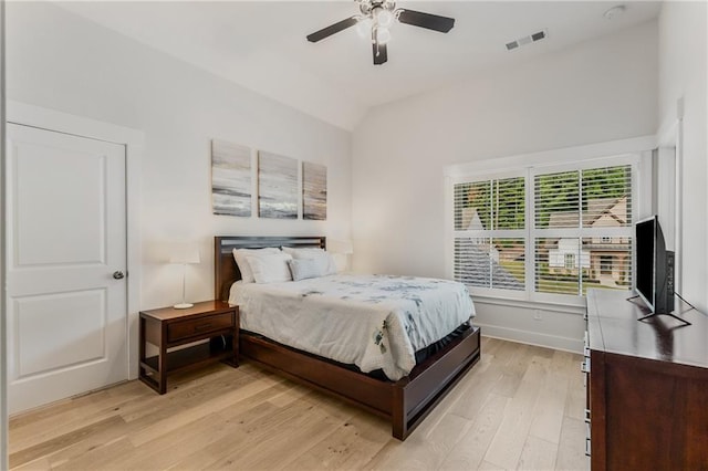 bedroom featuring ceiling fan, light hardwood / wood-style flooring, and lofted ceiling