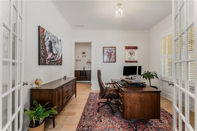 office area featuring crown molding, light hardwood / wood-style flooring, and french doors