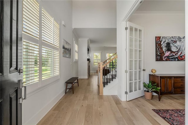 corridor featuring light wood-type flooring and ornamental molding