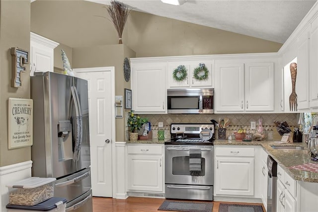 1784 Virginia Grove Ln, Lawrenceville, GA 30045 - kitchen featuring stainless steel appliances, white cabinetry, backsplash, and vaulted ceiling
