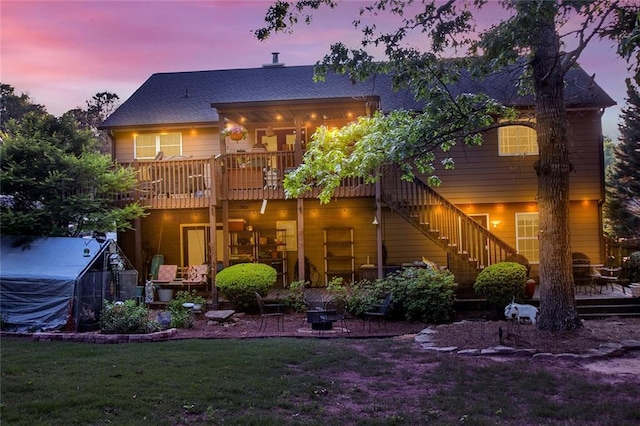 1784 Virginia Grove Ln, Lawrenceville, GA 30045 - back of property at dusk featuring a wooden deck, a greenhouse, an outdoor structure, stairway, and a yard