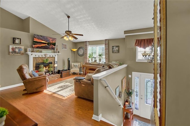 1784 Virginia Grove Ln, Lawrenceville, GA 30045 - living room with wood finished floors, a stone fireplace, ceiling fan, a textured ceiling, and lofted ceiling