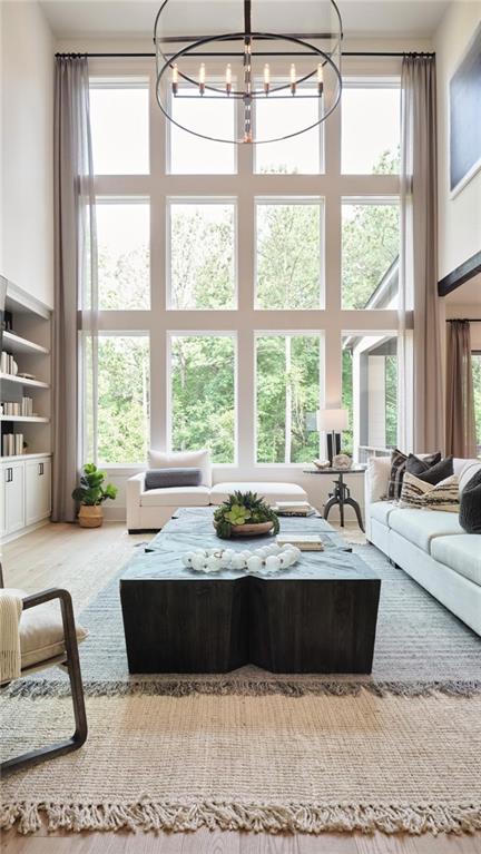 living room featuring a high ceiling, built in features, and a chandelier