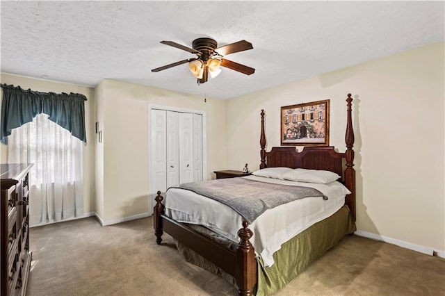 bedroom featuring carpet flooring, baseboards, a closet, and a textured ceiling