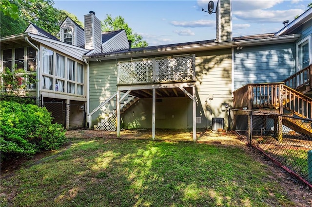 rear view of house featuring stairway, a chimney, a sunroom, and a deck