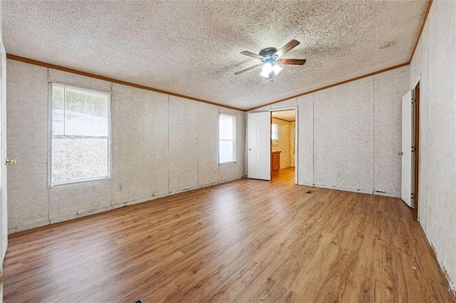 unfurnished bedroom featuring ornamental molding, a textured ceiling, ceiling fan, and wood finished floors