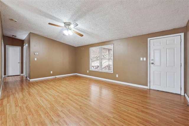 unfurnished living room with a ceiling fan, baseboards, light wood finished floors, and a textured ceiling