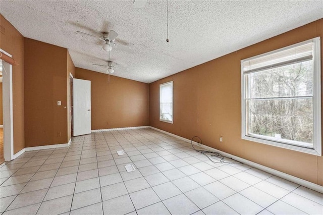 empty room featuring light tile patterned floors, baseboards, a textured ceiling, and ceiling fan