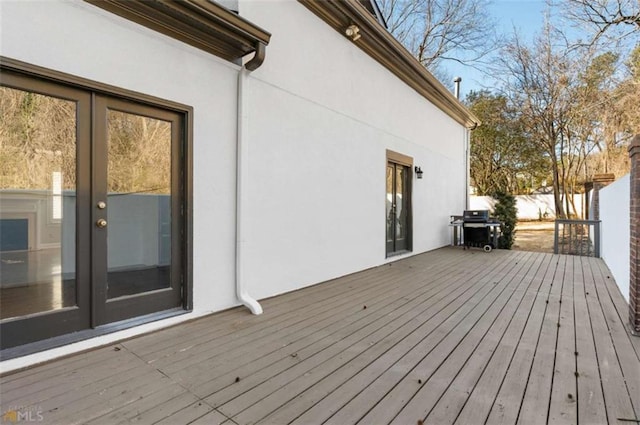 wooden deck with a grill and french doors