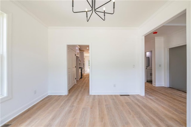 unfurnished room with light hardwood / wood-style floors, an inviting chandelier, and crown molding