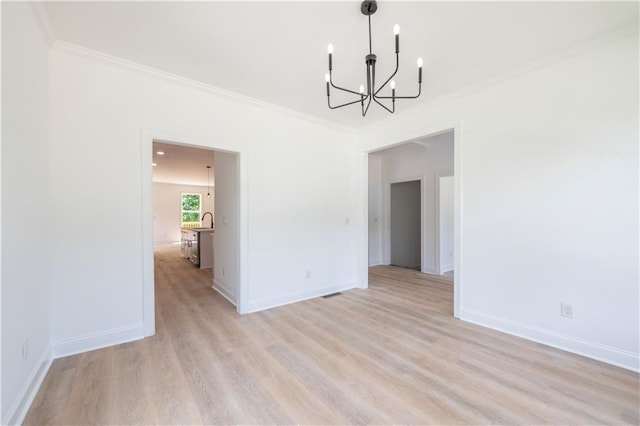 unfurnished dining area with an inviting chandelier, ornamental molding, and light hardwood / wood-style floors