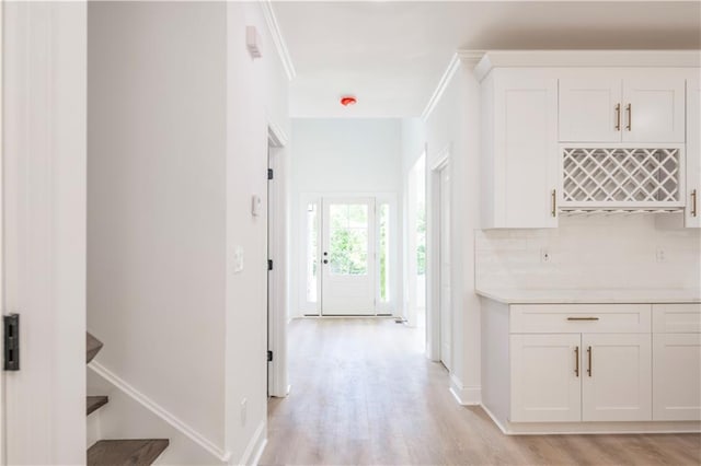 corridor featuring ornamental molding and light wood-type flooring