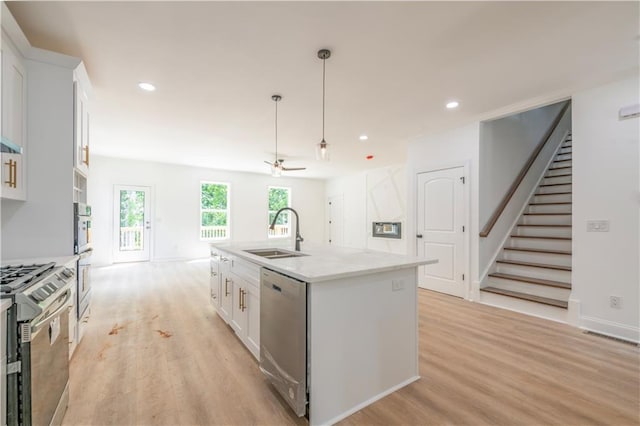 kitchen with sink, ceiling fan, a kitchen island with sink, and appliances with stainless steel finishes