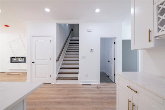 stairs featuring crown molding and wood-type flooring