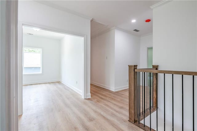 corridor featuring light wood-type flooring and crown molding