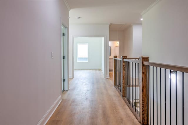 hallway with ornamental molding and light hardwood / wood-style floors