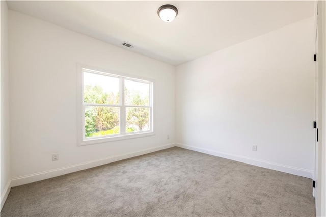 spare room featuring light colored carpet