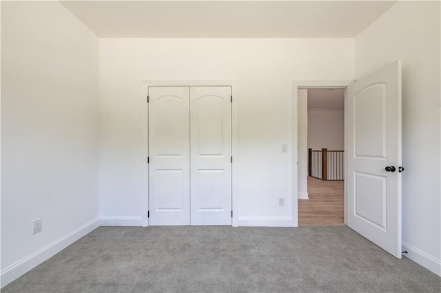 unfurnished bedroom with a closet and light carpet