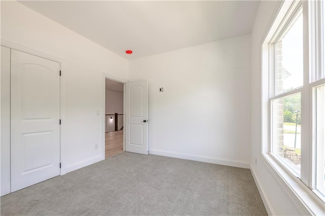 unfurnished bedroom featuring a closet and light colored carpet