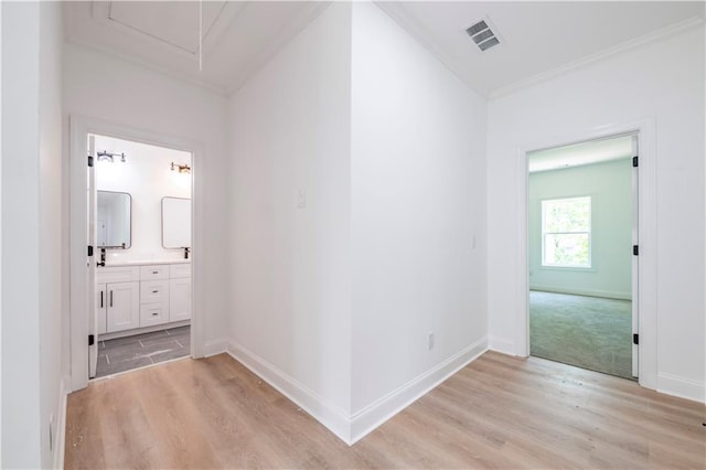 hallway featuring ornamental molding and light hardwood / wood-style floors