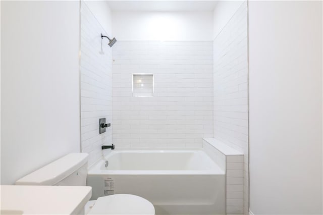 bathroom with toilet and tiled shower / bath