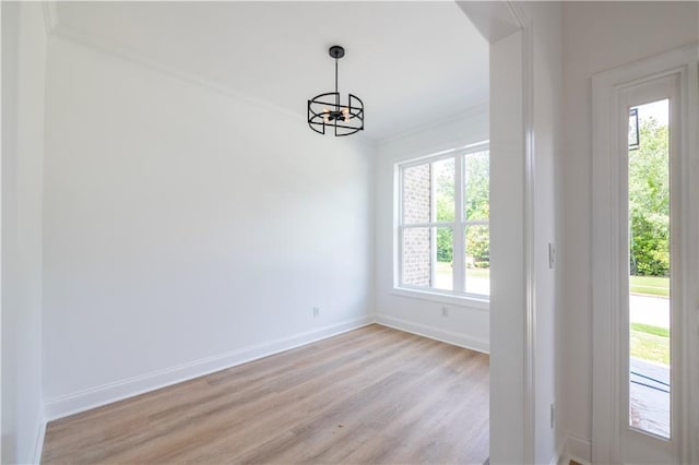 interior space featuring ornamental molding, light hardwood / wood-style floors, and a chandelier