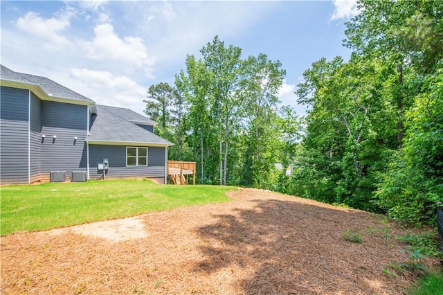 view of yard featuring central AC unit and a wooden deck