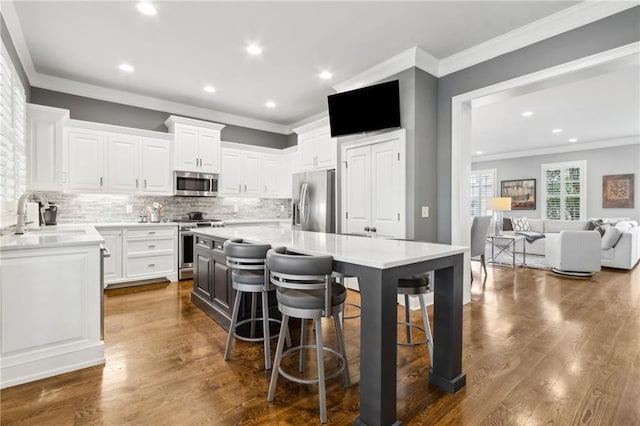 2362 Saint Davids Sq NW, Kennesaw, GA 30152 - kitchen with appliances with stainless steel finishes, a sink, white cabinetry, ornamental molding, and decorative backsplash
