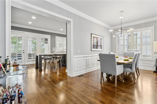2362 Saint Davids Sq NW, Kennesaw, GA 30152 - dining space with ornamental molding, a wainscoted wall, a decorative wall, dark wood-style flooring, and a chandelier