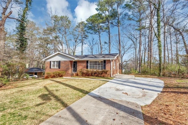 view of front of property with a front yard, brick siding, and driveway