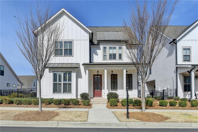 modern inspired farmhouse featuring a porch, board and batten siding, a standing seam roof, metal roof, and fence