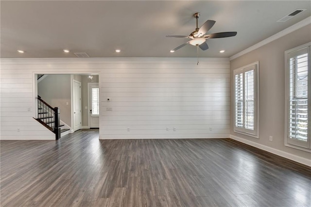 spare room with dark wood-type flooring, visible vents, stairway, and baseboards